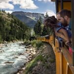Vater und Tochter gucken aus einem historischen Zug in Colorado