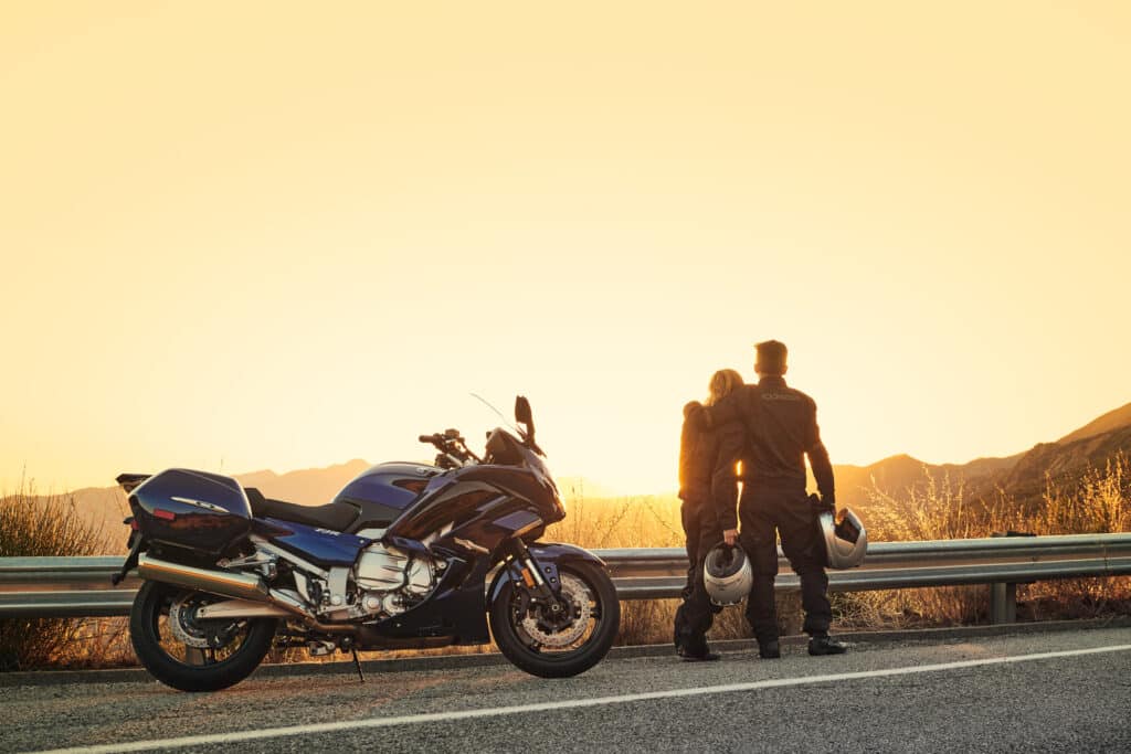 Pärchen vor dem Sonnenuntergang mit Motorrad